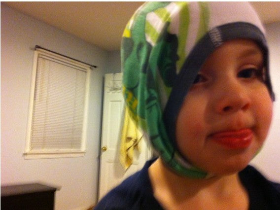 Child wearing a dinosaur-themed underwear indoors